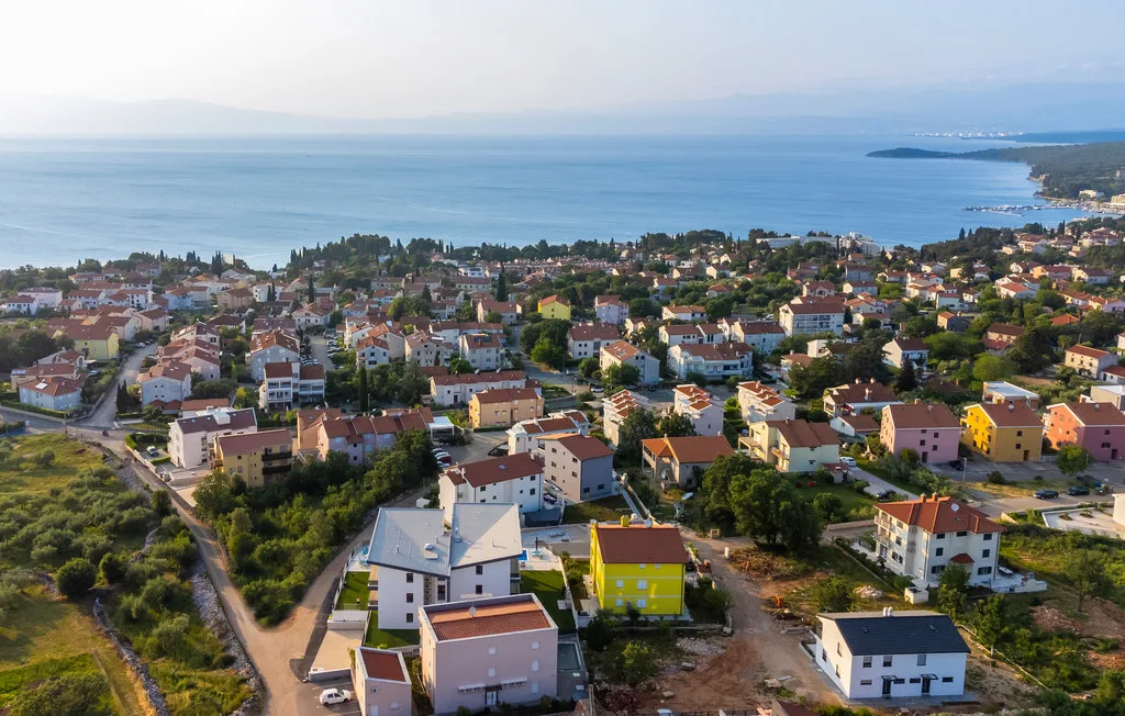 An aerial view of a coastal town with houses beside the sea.