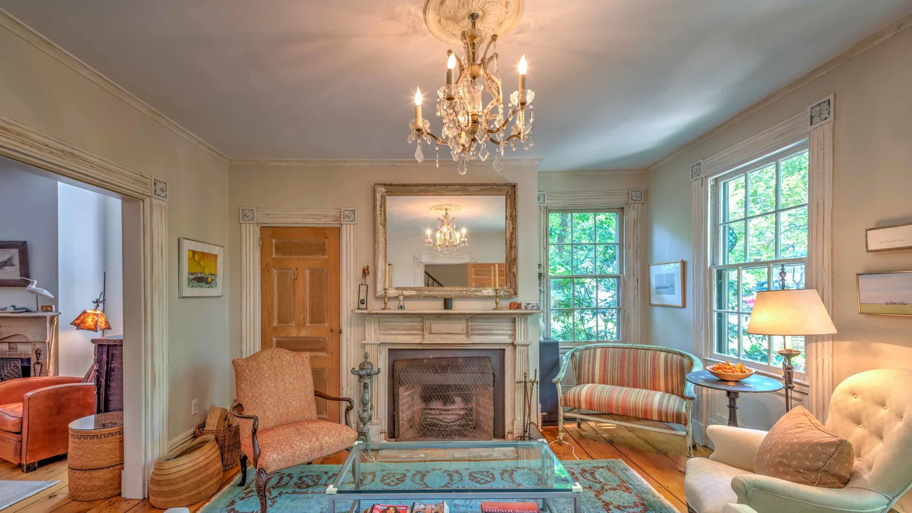 A living room with a fireplace, seating, and a glass coffee table.