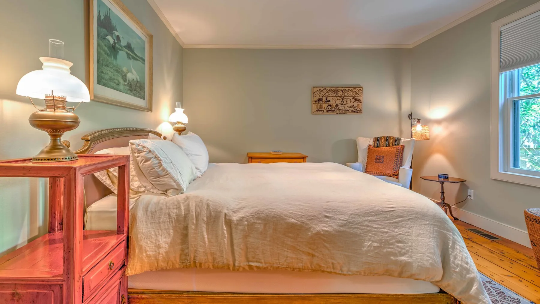 Un dormitorio con una cama grande, mesitas de noche y una ventana.