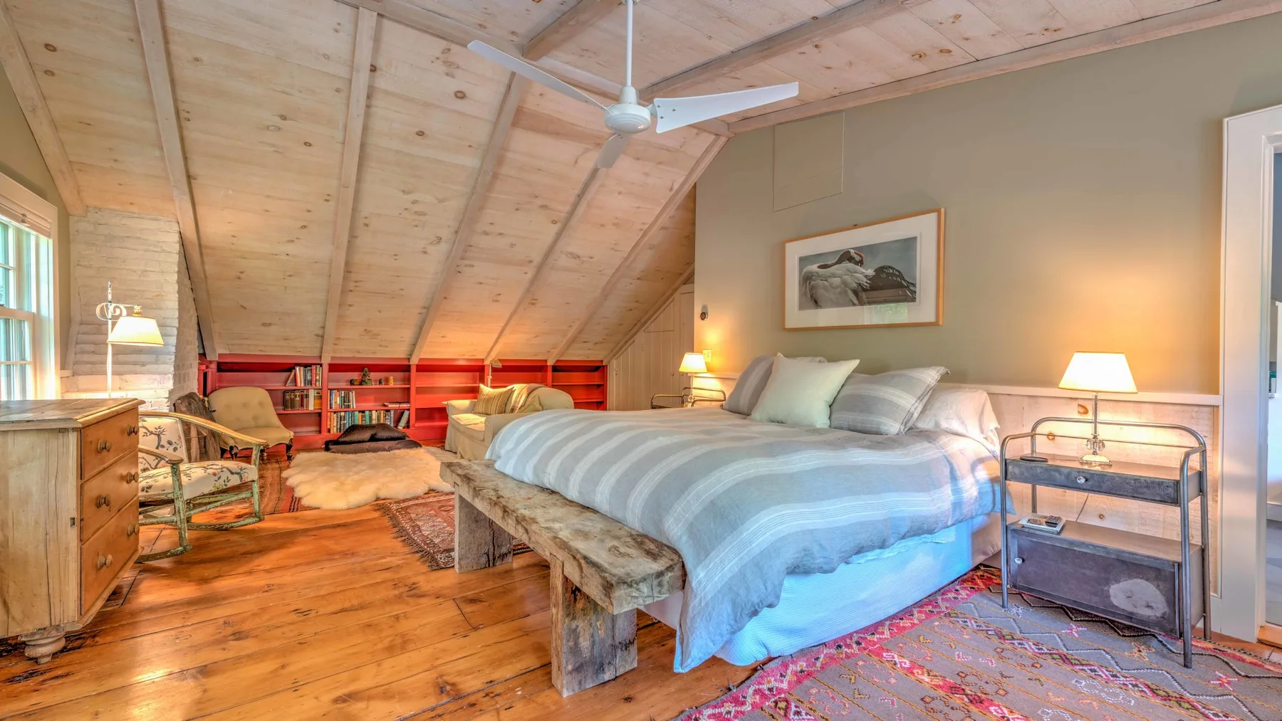 Un dormitorio con una cama grande, techo de madera y ventilador de techo.