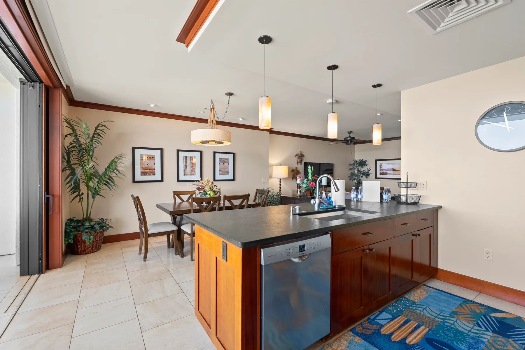Una cocina moderna con una isla grande y una mesa de comedor junto a amplias ventanas.