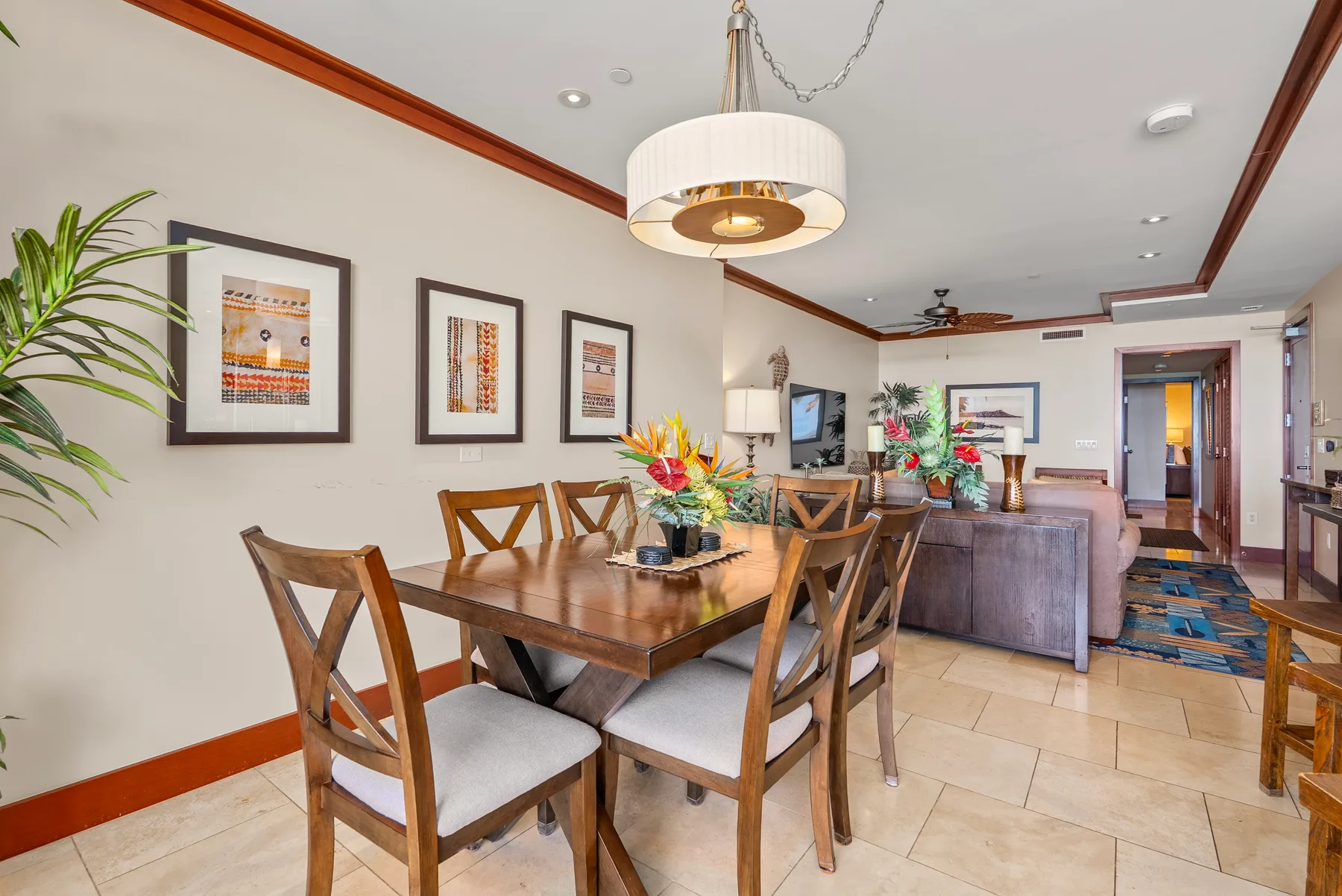 Un comedor con mesa de madera y asientos se abre a una sala de estar.