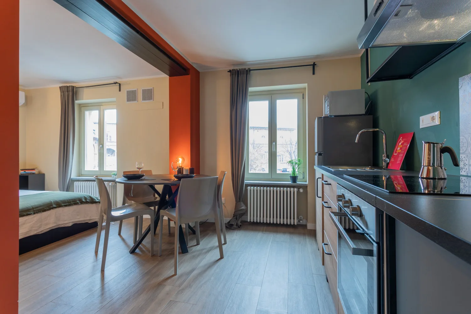 A combined kitchen and dining area with a table beside the windows.