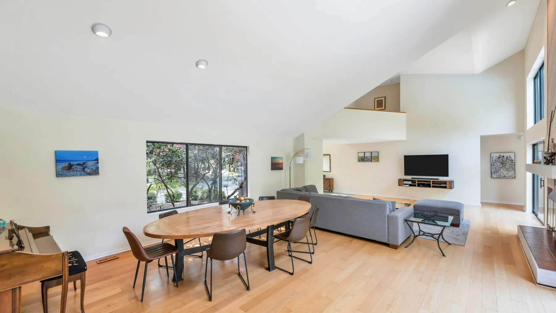 An open-plan living and dining area with a wooden dining table and gray seating.