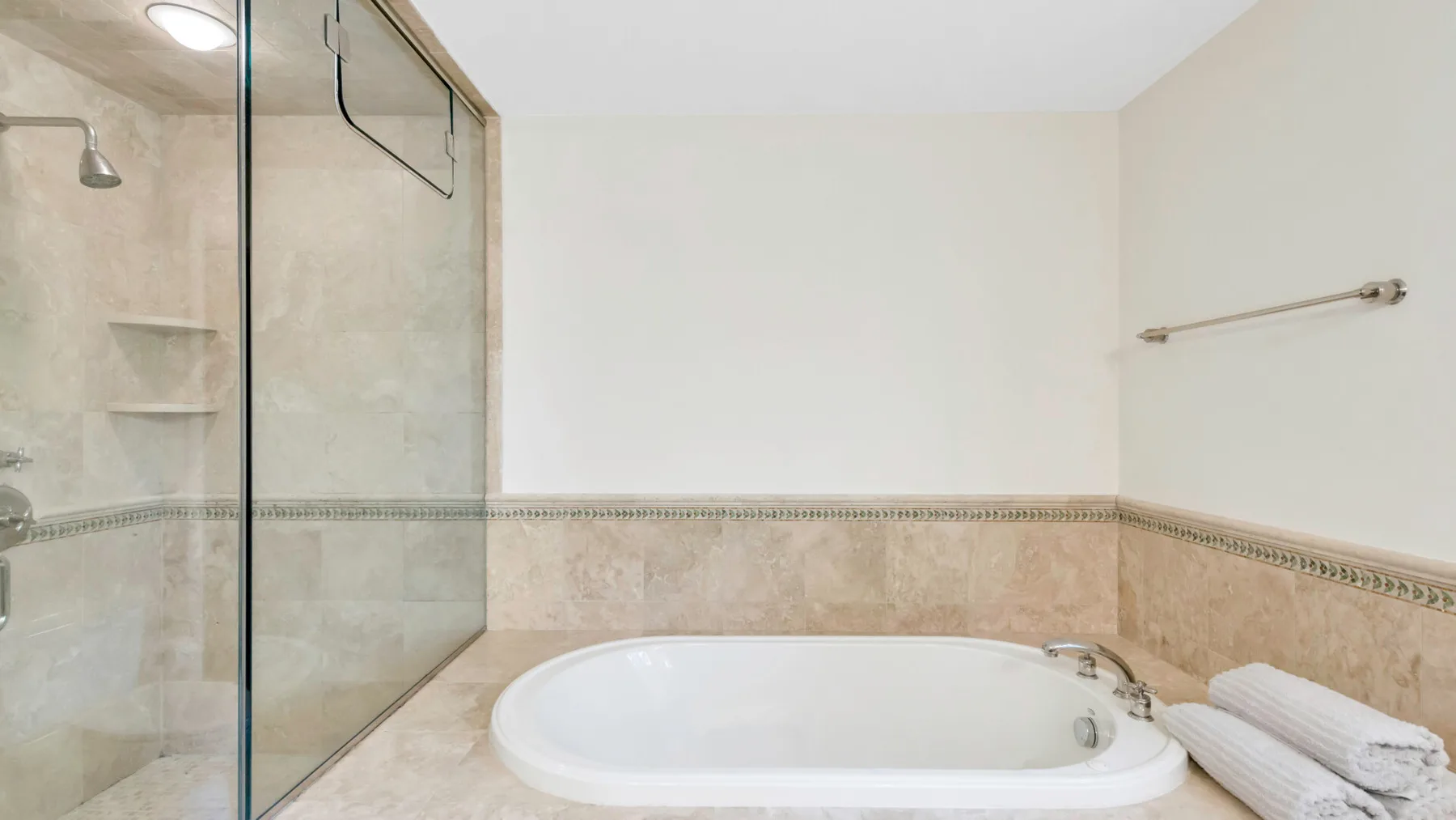 A bathroom with a bathtub and glass shower enclosure.