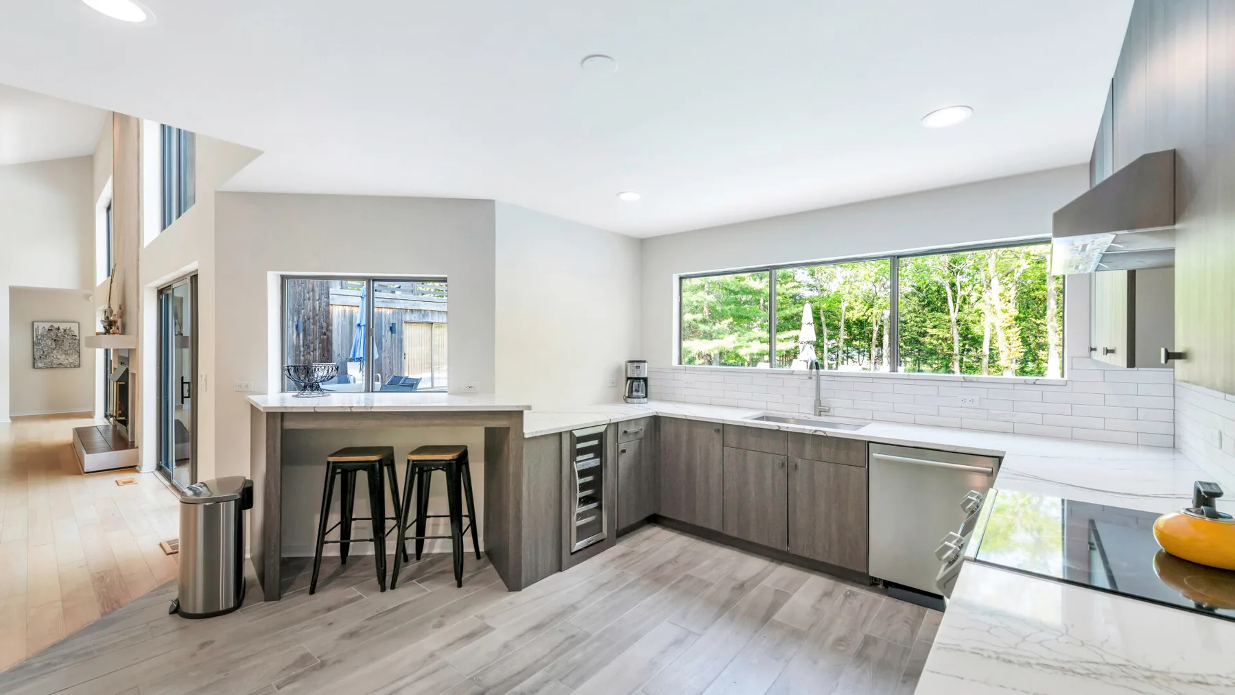 A bright modern kitchen with a breakfast bar and long countertop.
