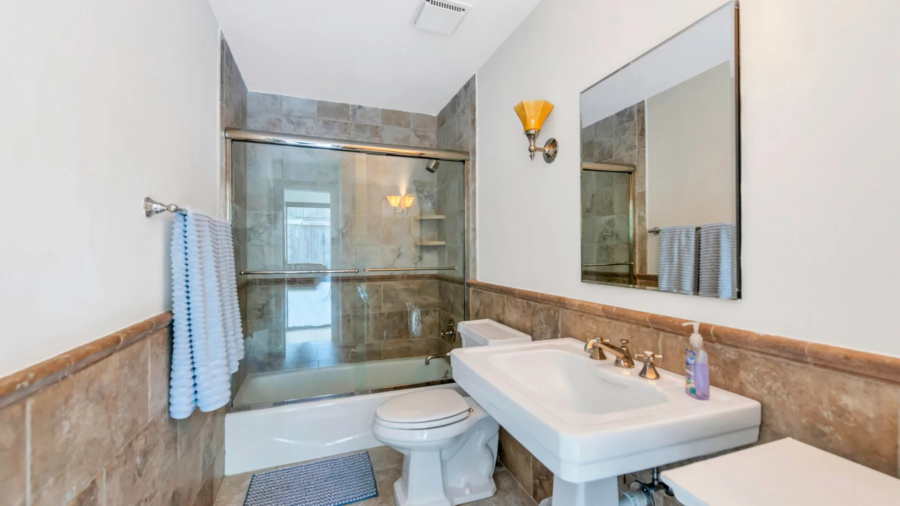 A bathroom with a glass shower, bathtub, and sink.