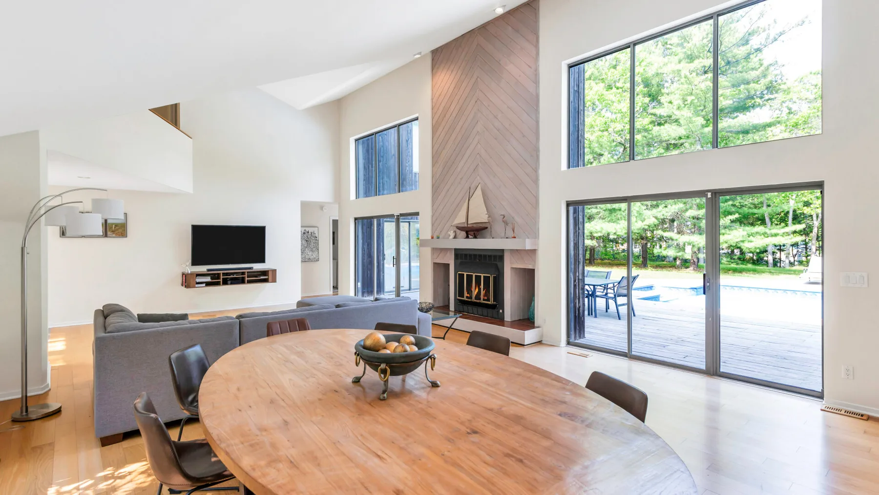 A bright living and dining area opens onto a patio through large windows.