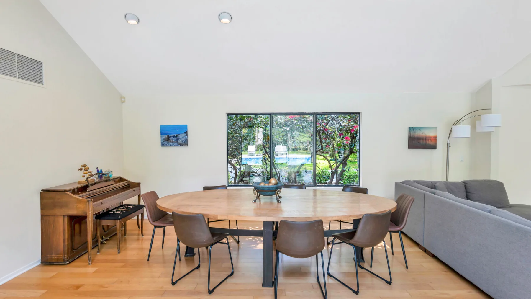 A dining area with a large table and chairs beside a living area.