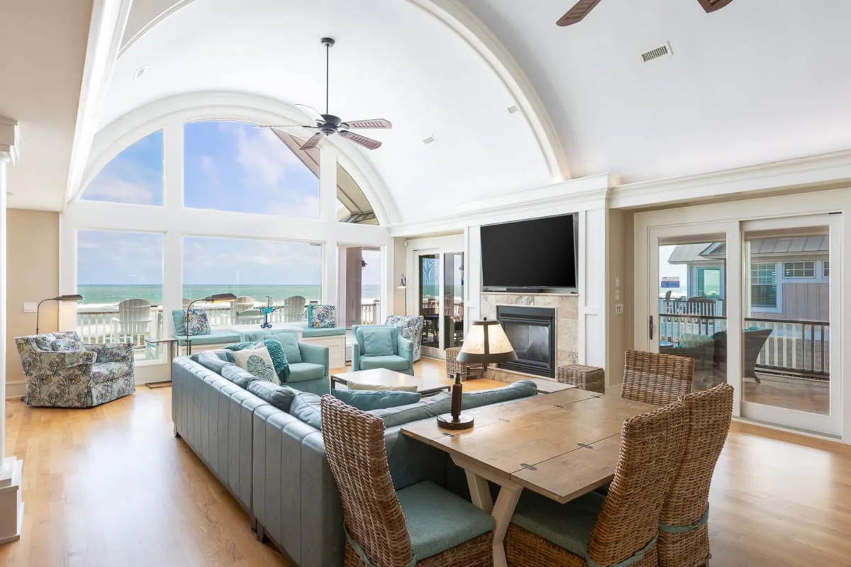 A bright living and dining area opens onto a balcony with ocean views.