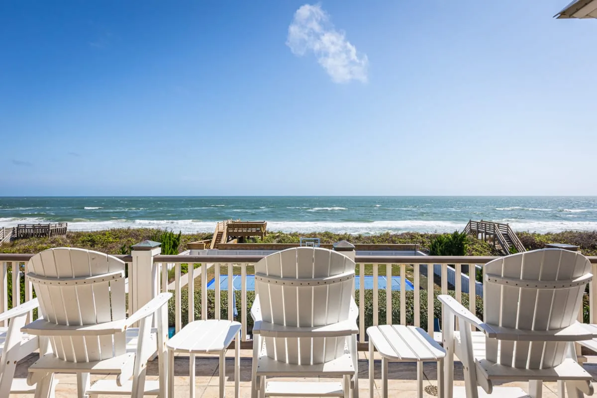 Outdoor deck seating overlooks the ocean and sandy beach.