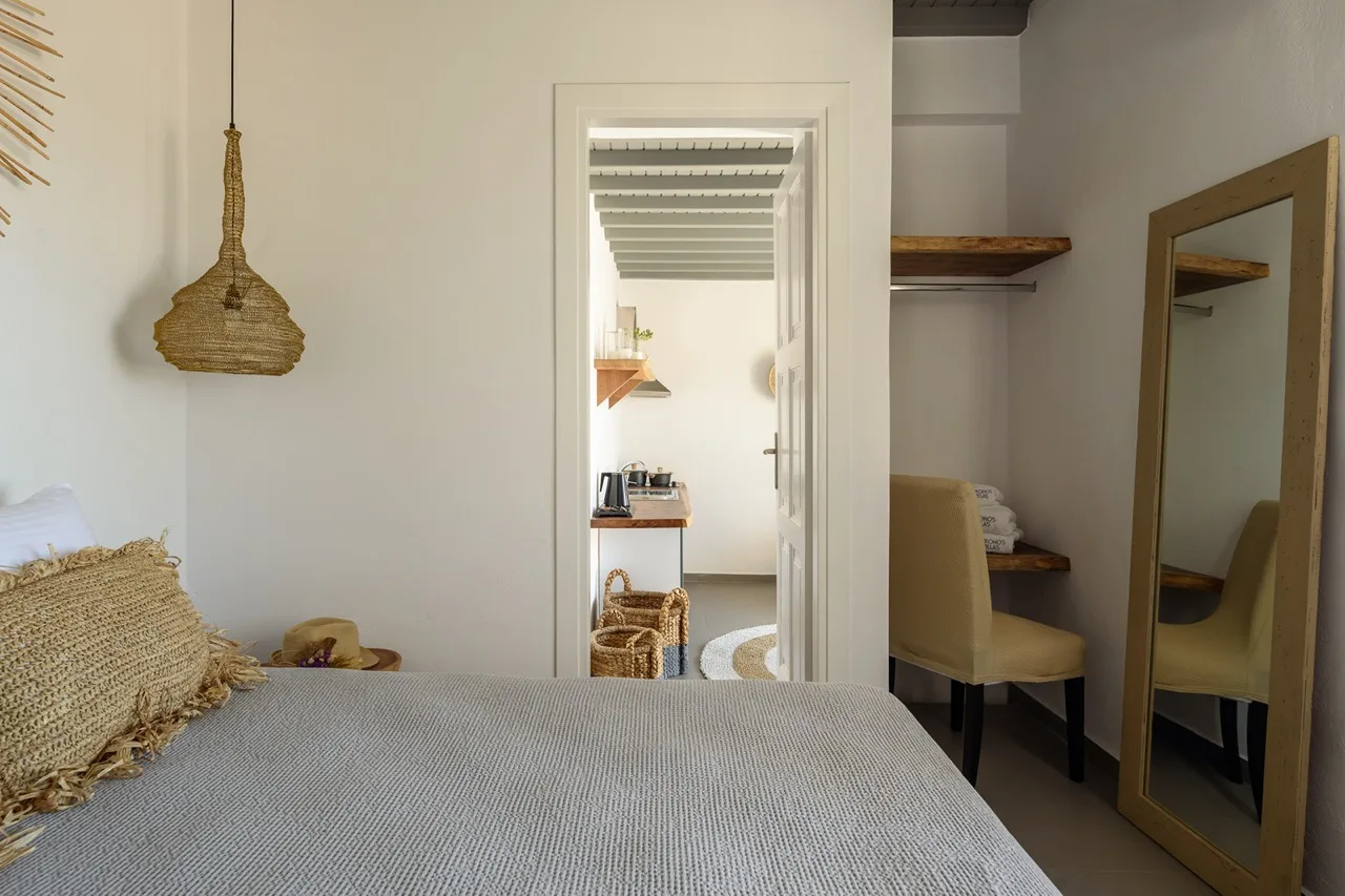 A bedroom with a bed and a doorway leading to another room.