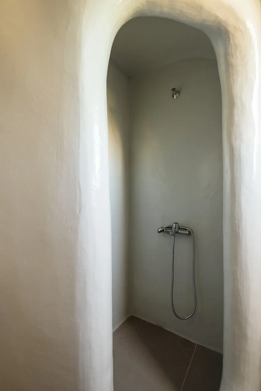 Una ducha empotrada con un grifo de ducha montado en la pared.