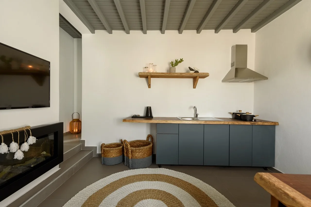 Una cocina compacta con gabinetes oscuros, una encimera y un estante en la pared.