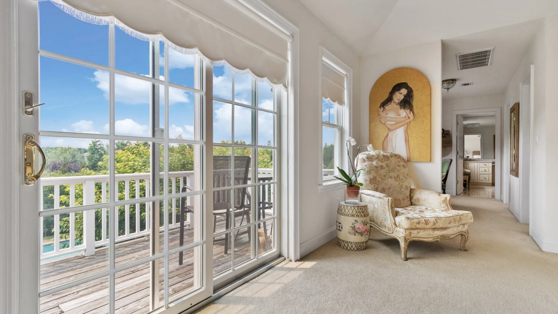 A bright living area opens onto a balcony through large glass doors.