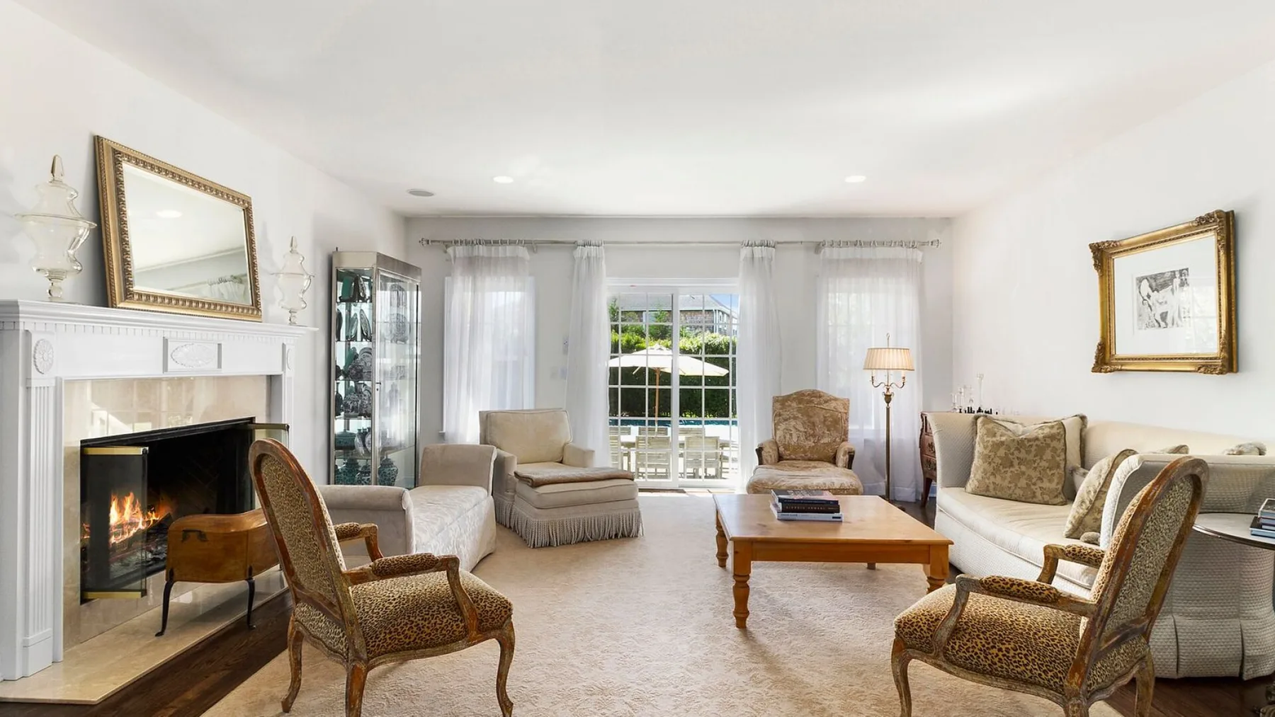 A bright living room with seating arranged around a coffee table and fireplace.