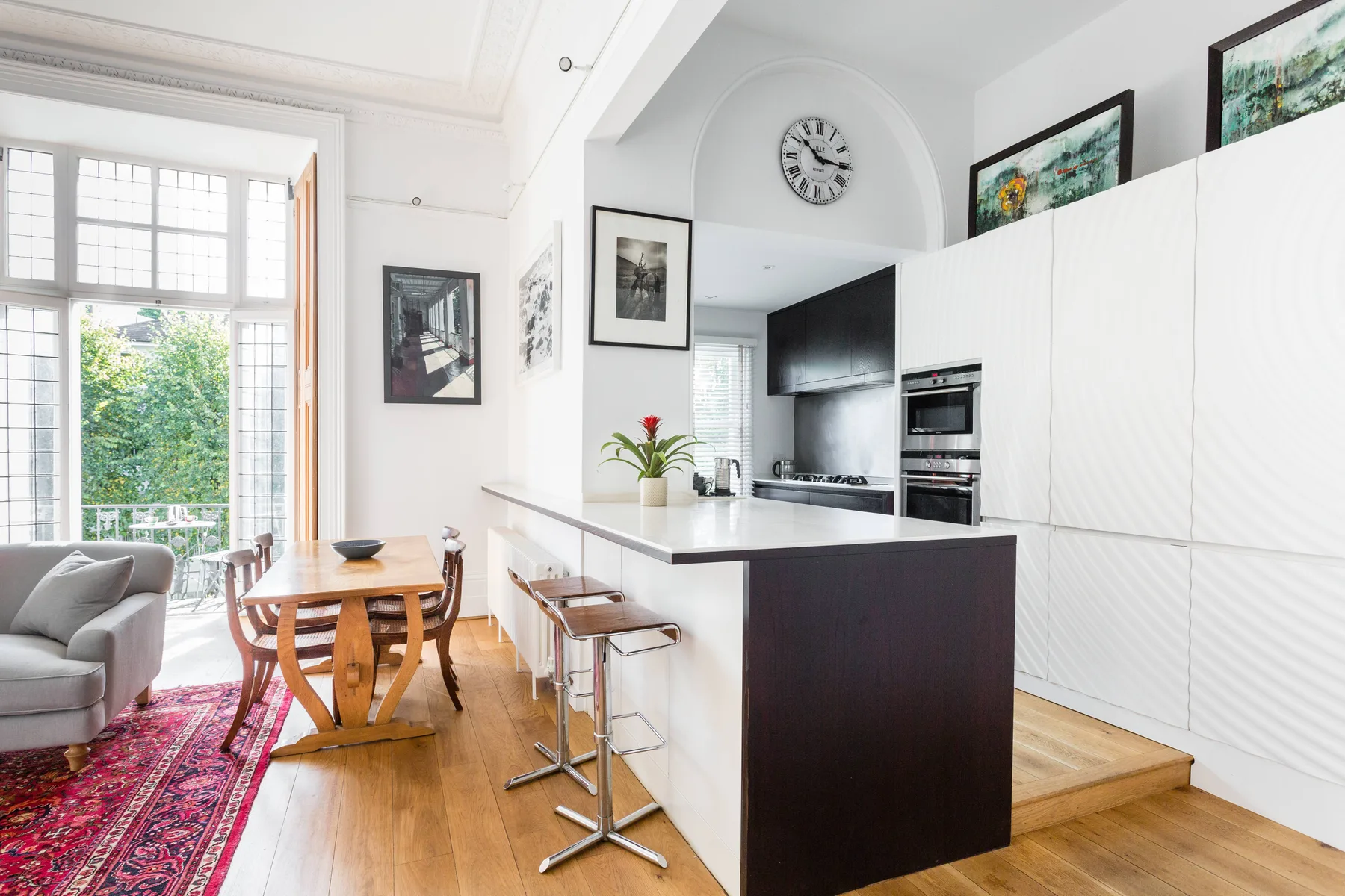 A bright open-plan living and dining area adjoins a kitchen with a central island.