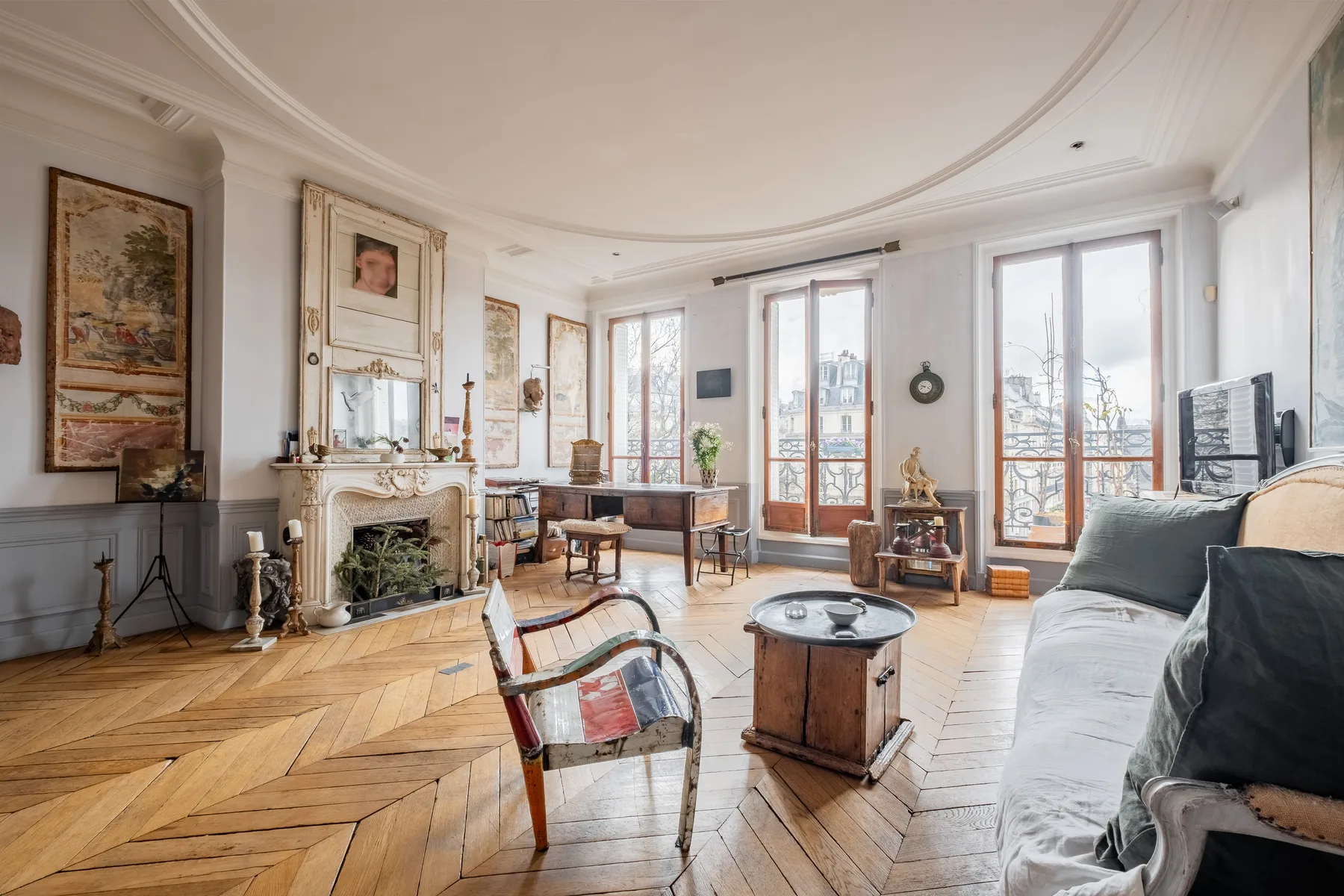 Una sala de estar luminosa con ventanas altas, una chimenea y asientos.