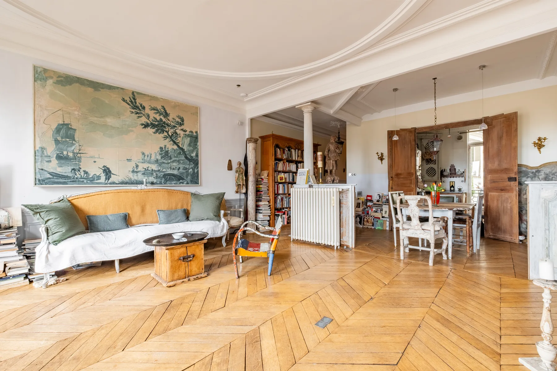 A living and dining room with a sofa, dining table, and wooden flooring.