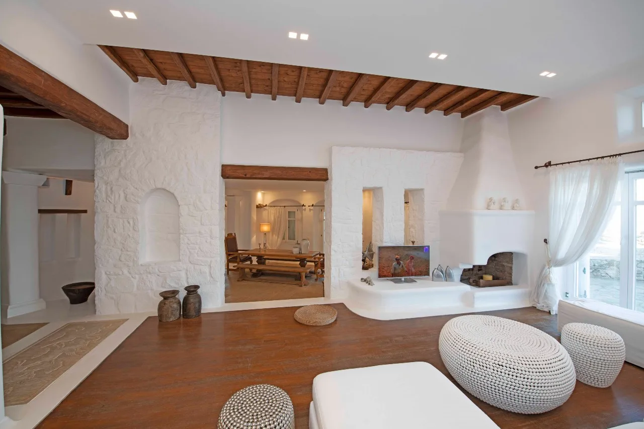 A bright living area features a fireplace, built-in seating, and exposed wooden beams.