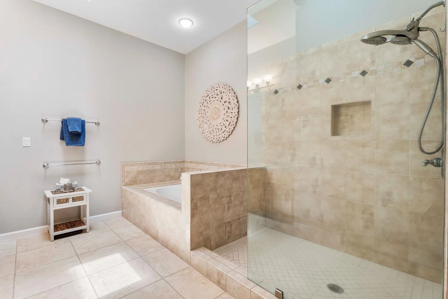 Un baño con azulejos, bañera y ducha con panel de vidrio.