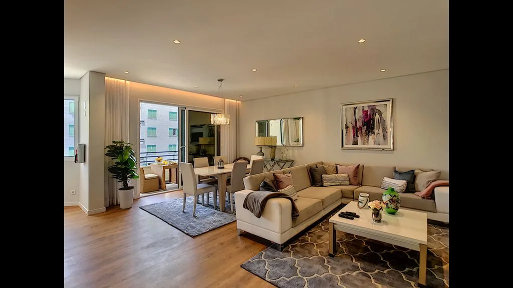A bright living and dining area with a sectional seating area and table.