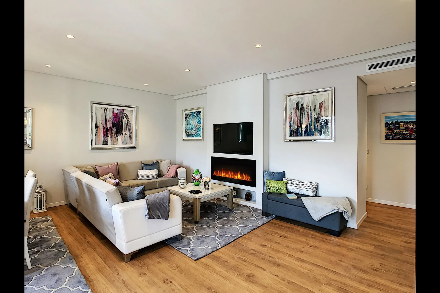 Living room with seating arranged around a coffee table and fireplace.