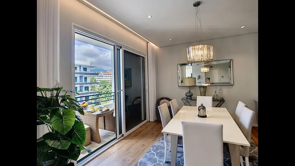 A dining area with a table beside sliding glass doors opening onto a balcony.