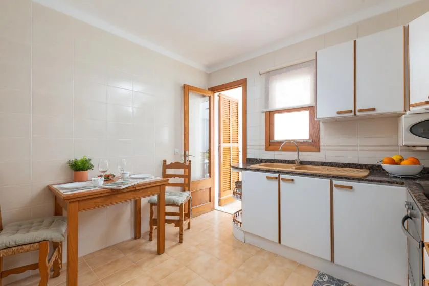 A bright kitchen with a dining table beside the counter and window.