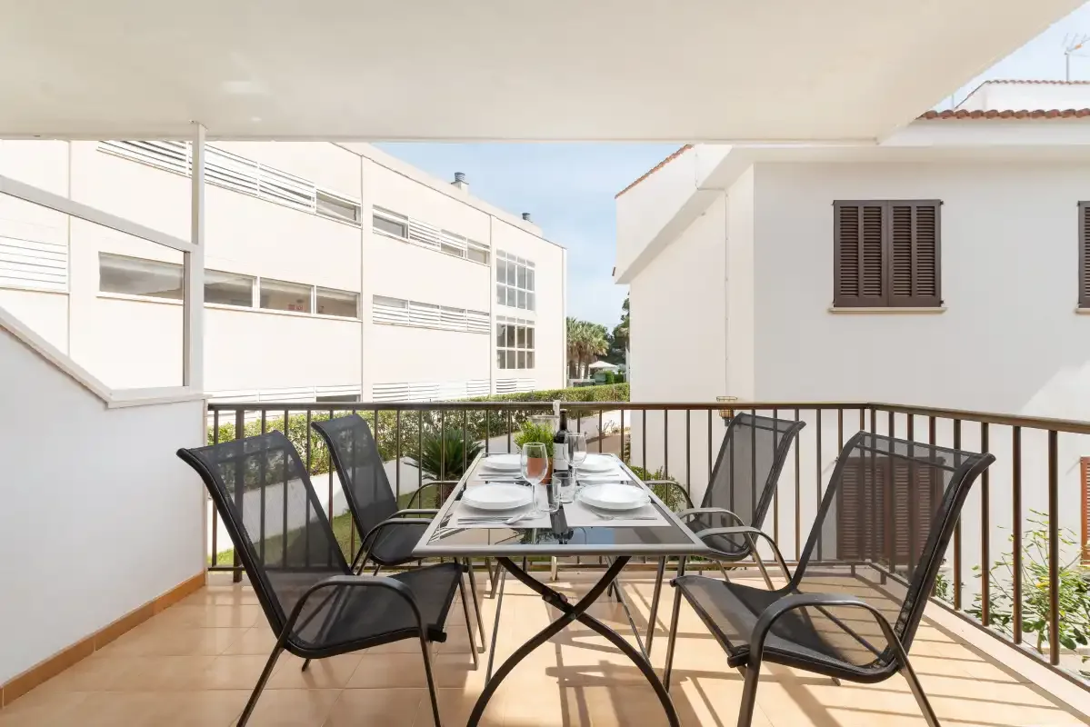 A terrace dining area with a table and seating overlooks nearby buildings.