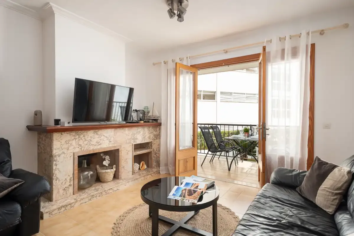 A living room opens onto a balcony through wide glass doors.
