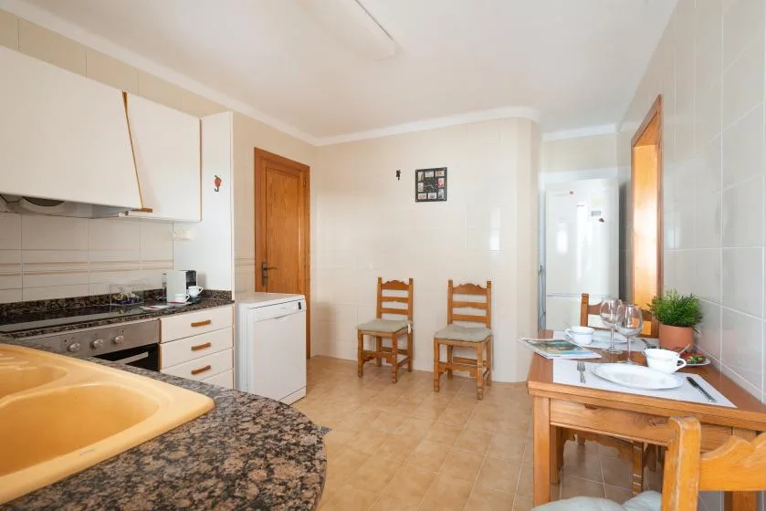 A kitchen and dining area with wooden seating and a countertop.