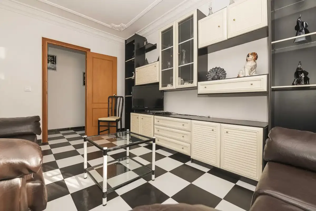 A living room with a black-and-white checkerboard floor and built-in cabinets.