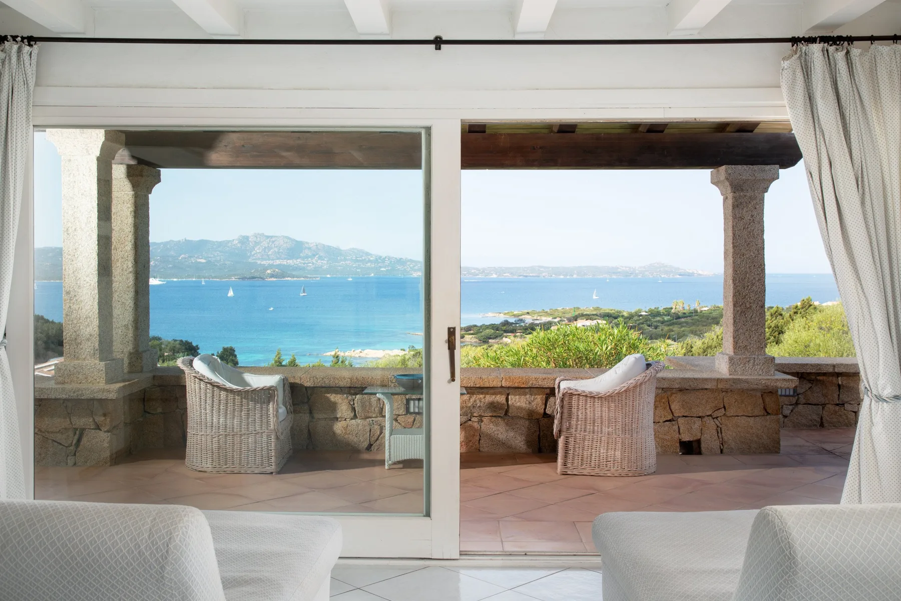 A bright sitting area opens onto a terrace with views of the sea.