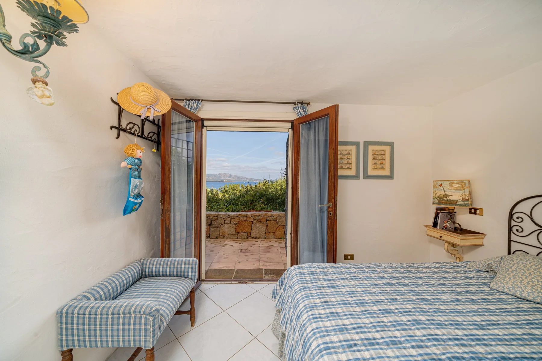 A bedroom with a bed and a glass-paneled door opening onto a balcony.