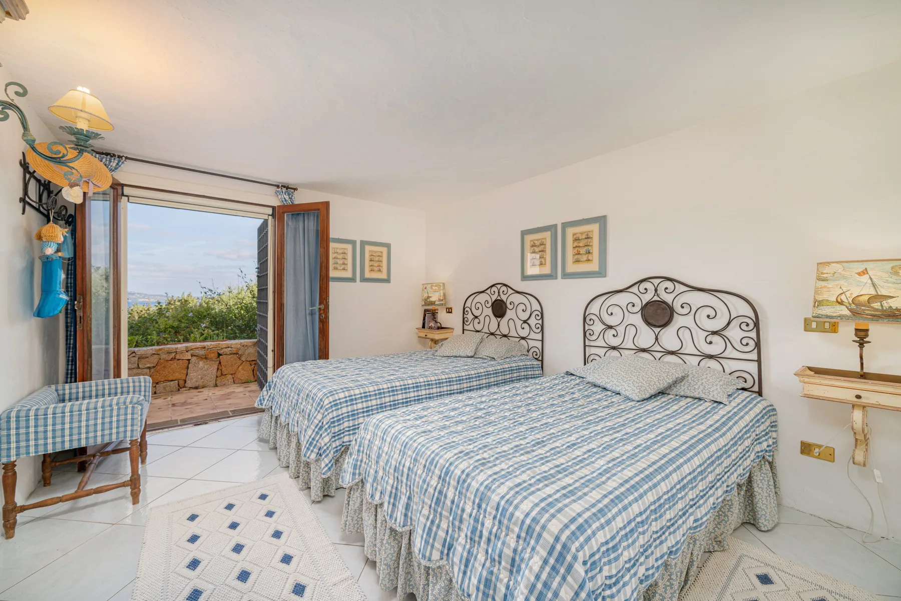 A bedroom with two beds dressed in blue-and-white checked bedding.
