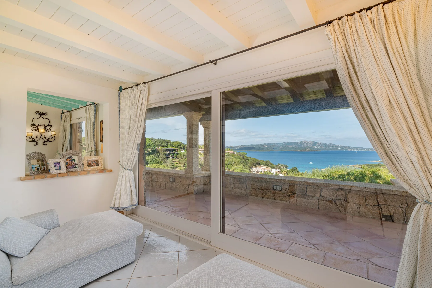 A bright sitting area opens onto a terrace overlooking the sea.
