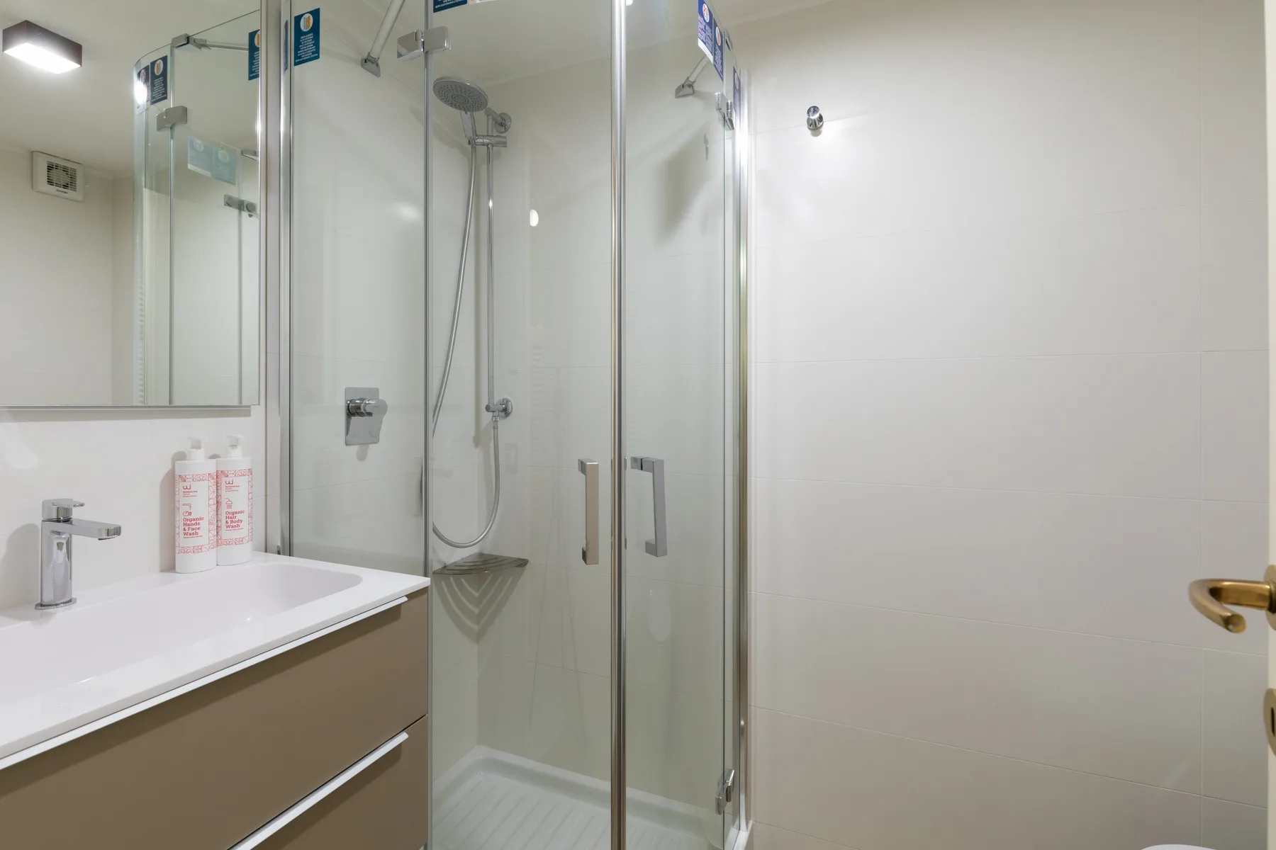A bathroom with a sink beside a glass-enclosed shower.