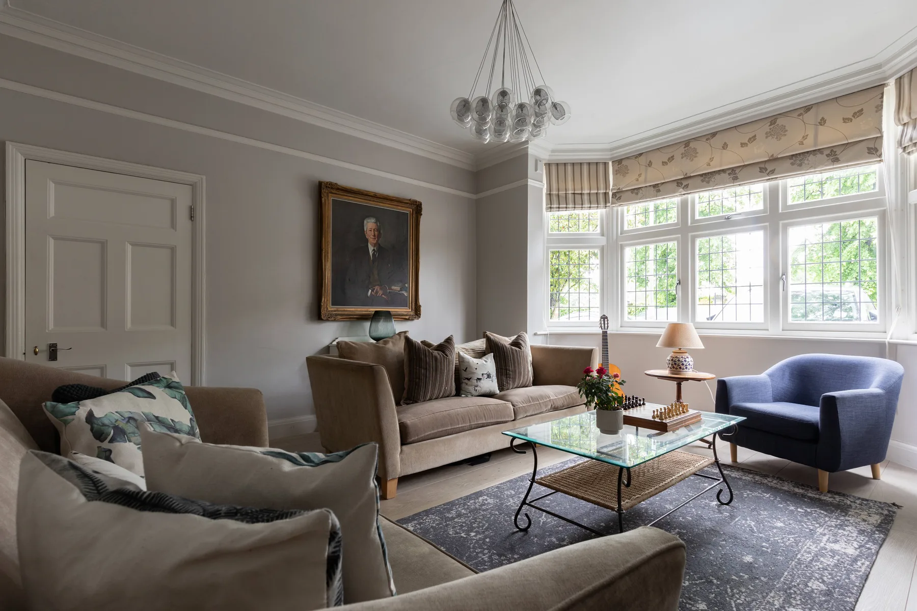 A bright living room with seating arranged around a glass coffee table.
