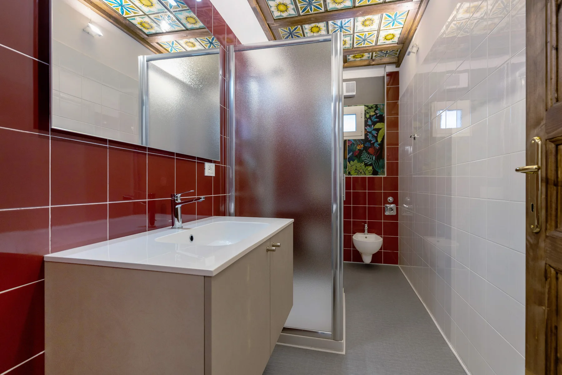 A tiled bathroom with a sink, shower, and toilet.