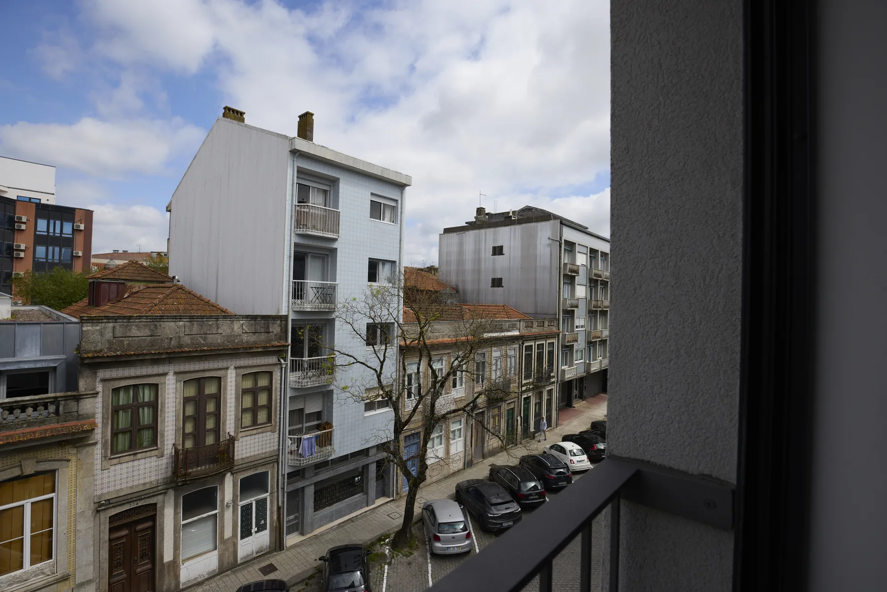 View of city buildings and a street from a balcony.