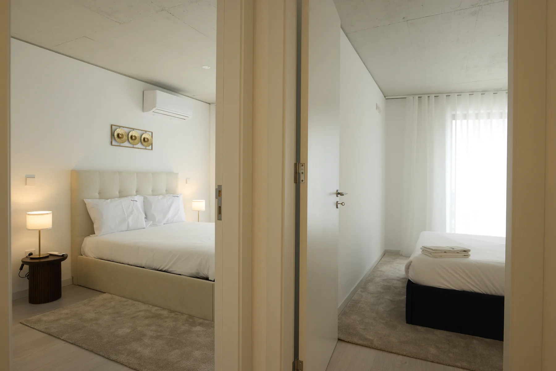 A bedroom with a neatly made bed and bedside lamps.