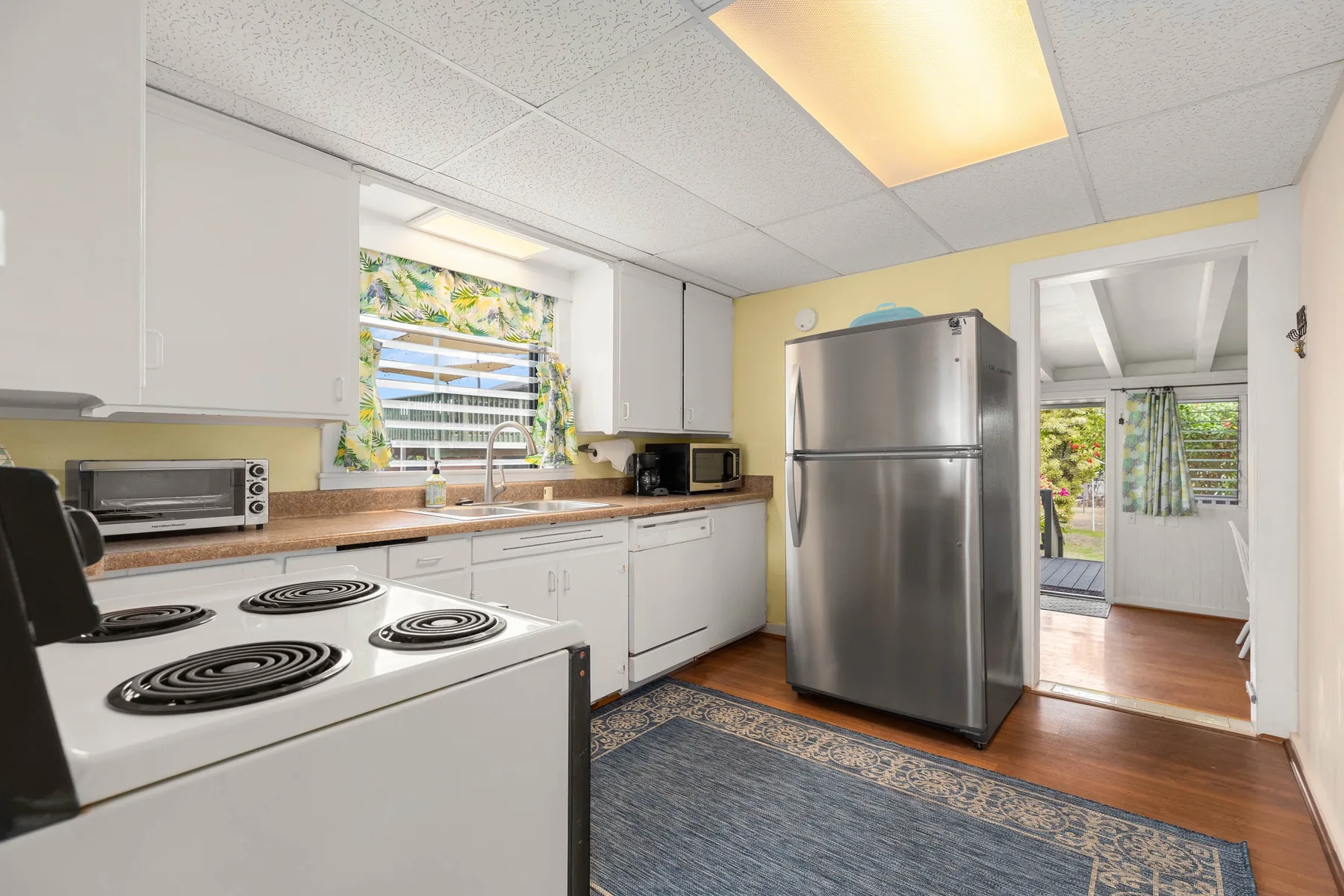 A bright kitchen with a refrigerator, stove, and countertop.