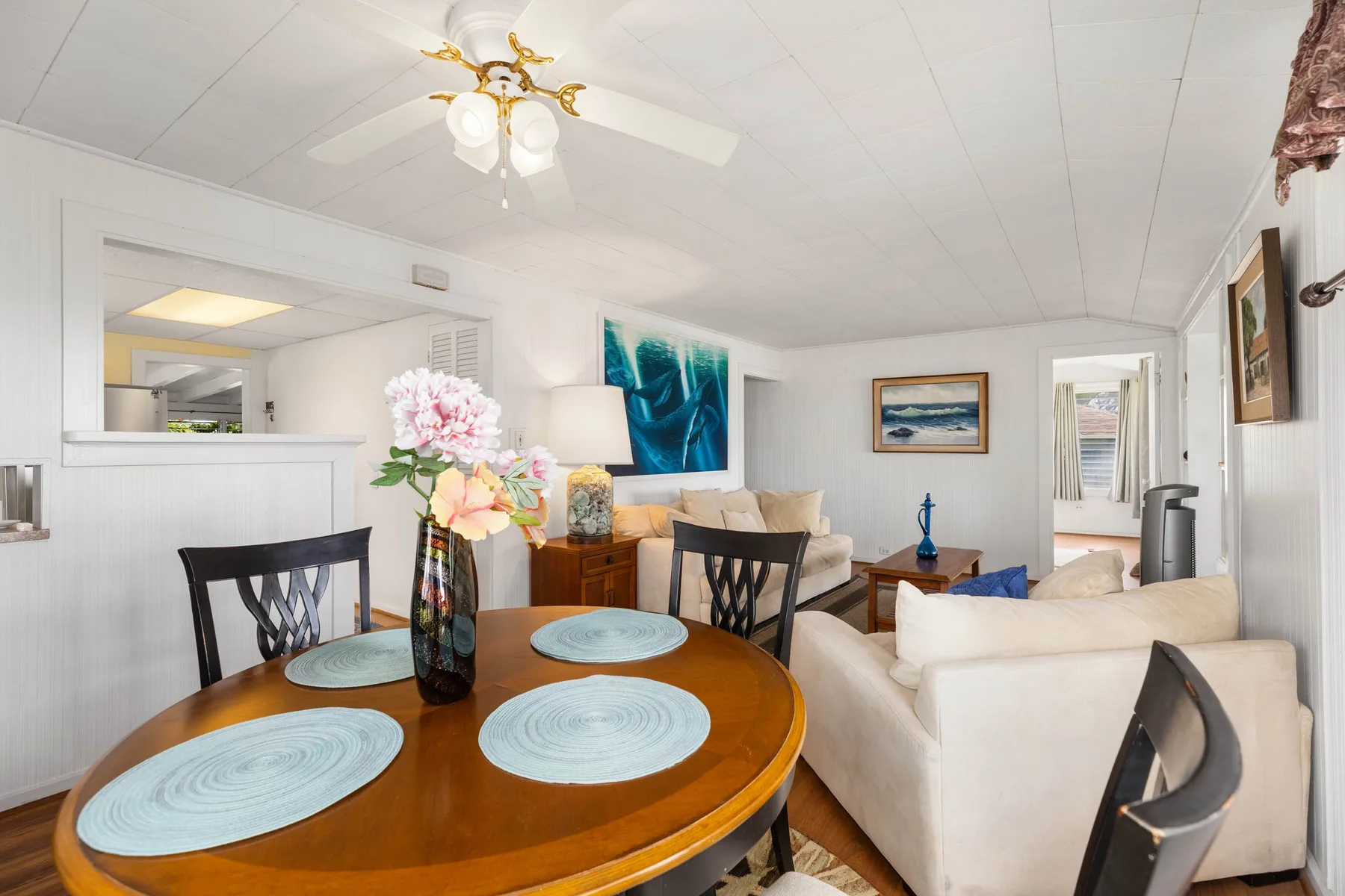 A bright living and dining room with a round table and seating.