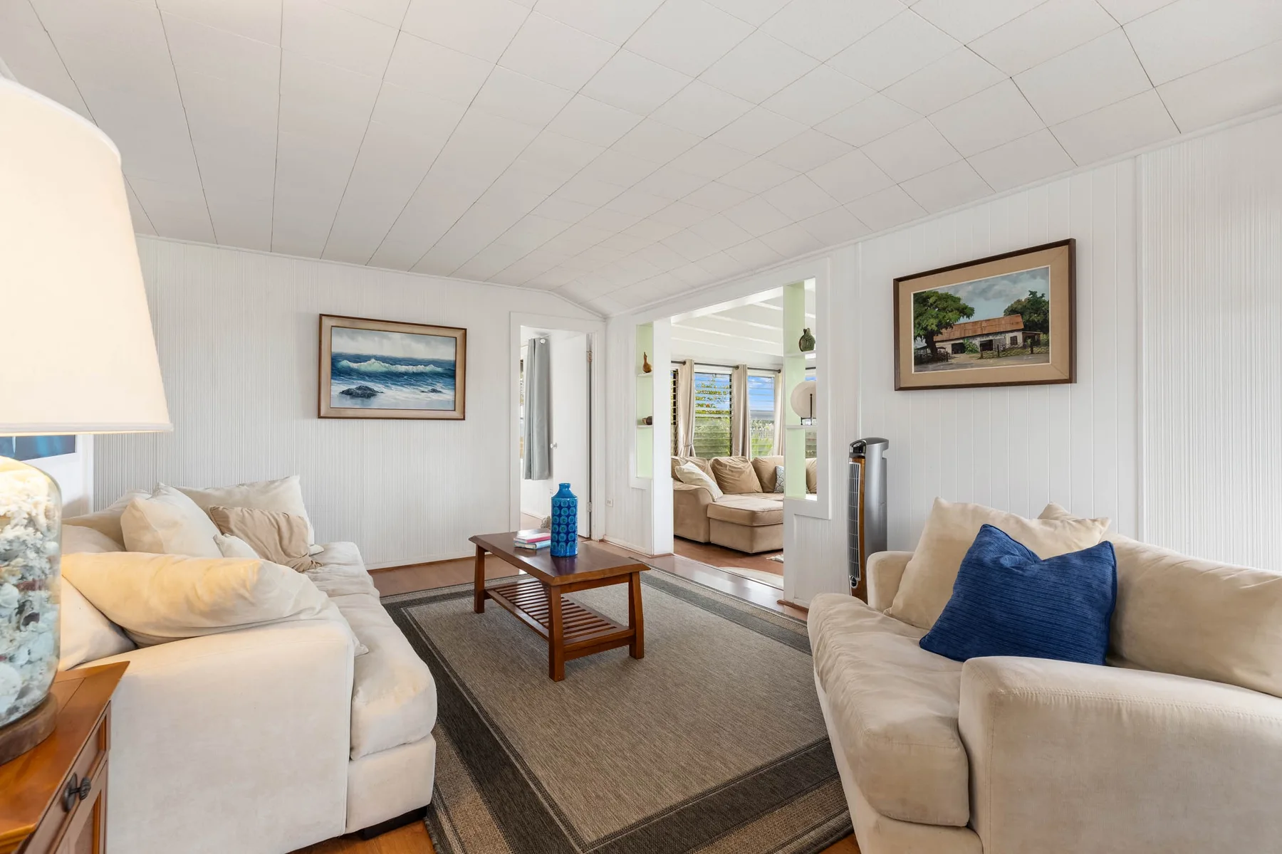 A bright living room with seating arranged around a wooden coffee table.