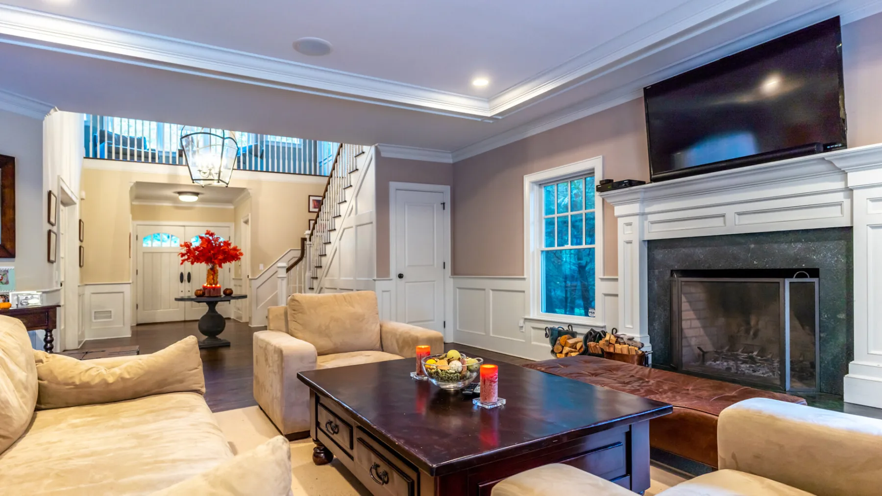 A bright living room with seating arranged around a dark coffee table and fireplace.