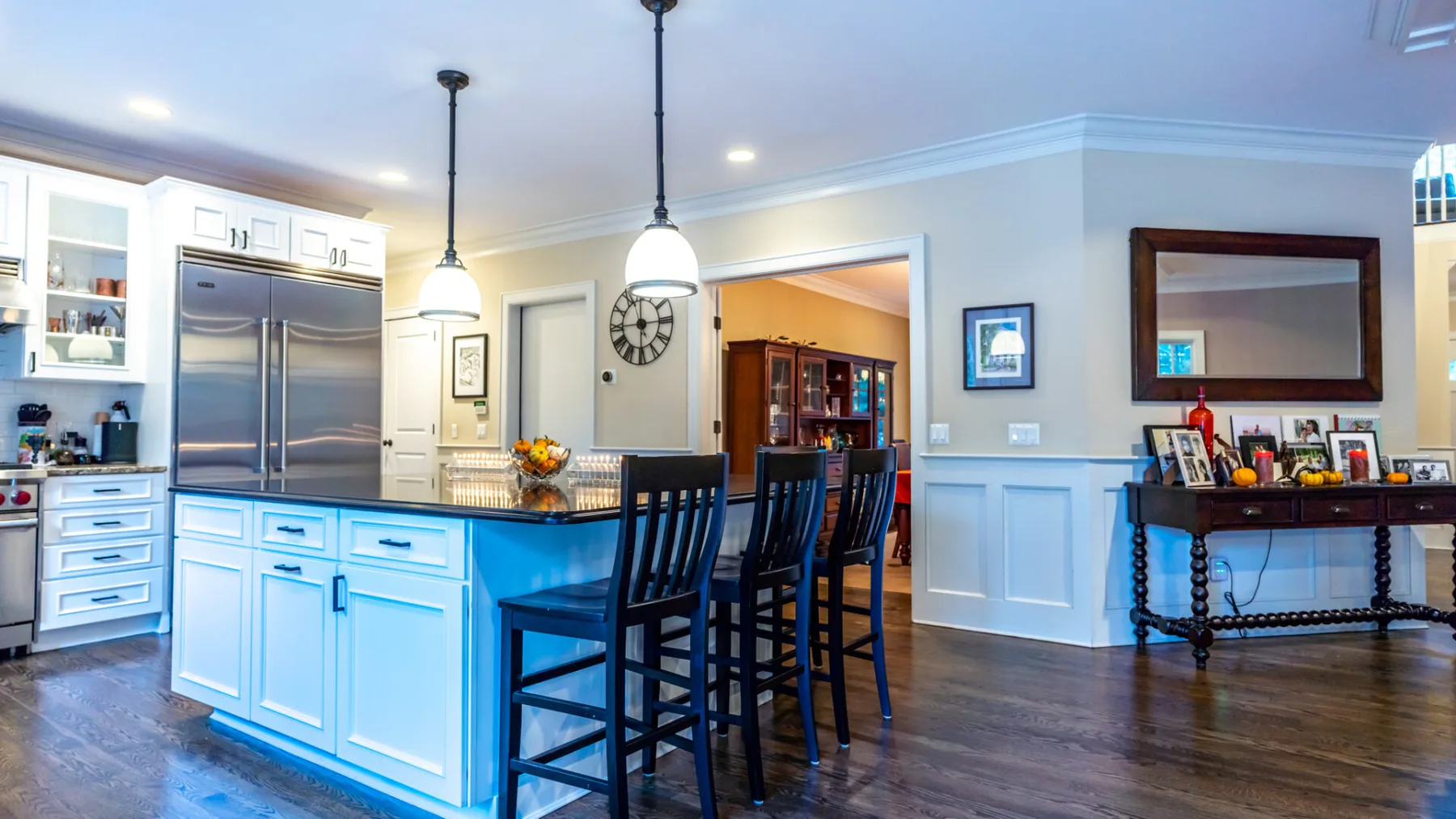A bright kitchen with a central island and dark bar seating.