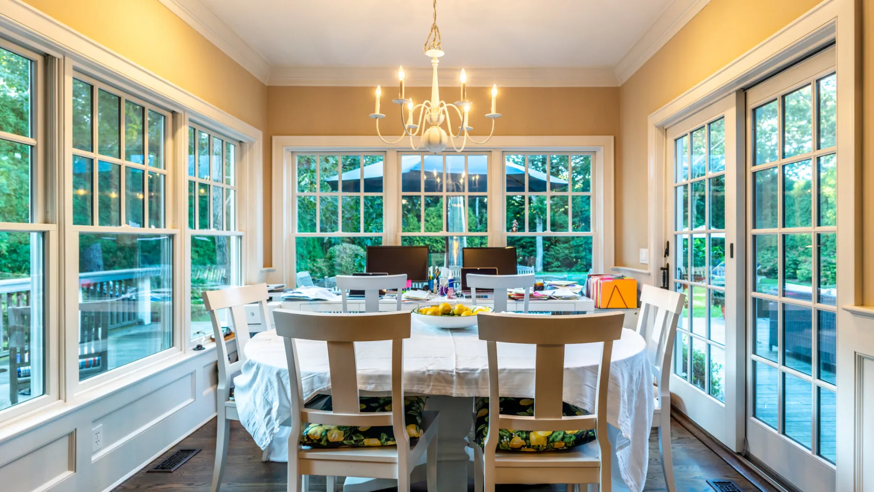 A bright dining room with a table set beside large windows.