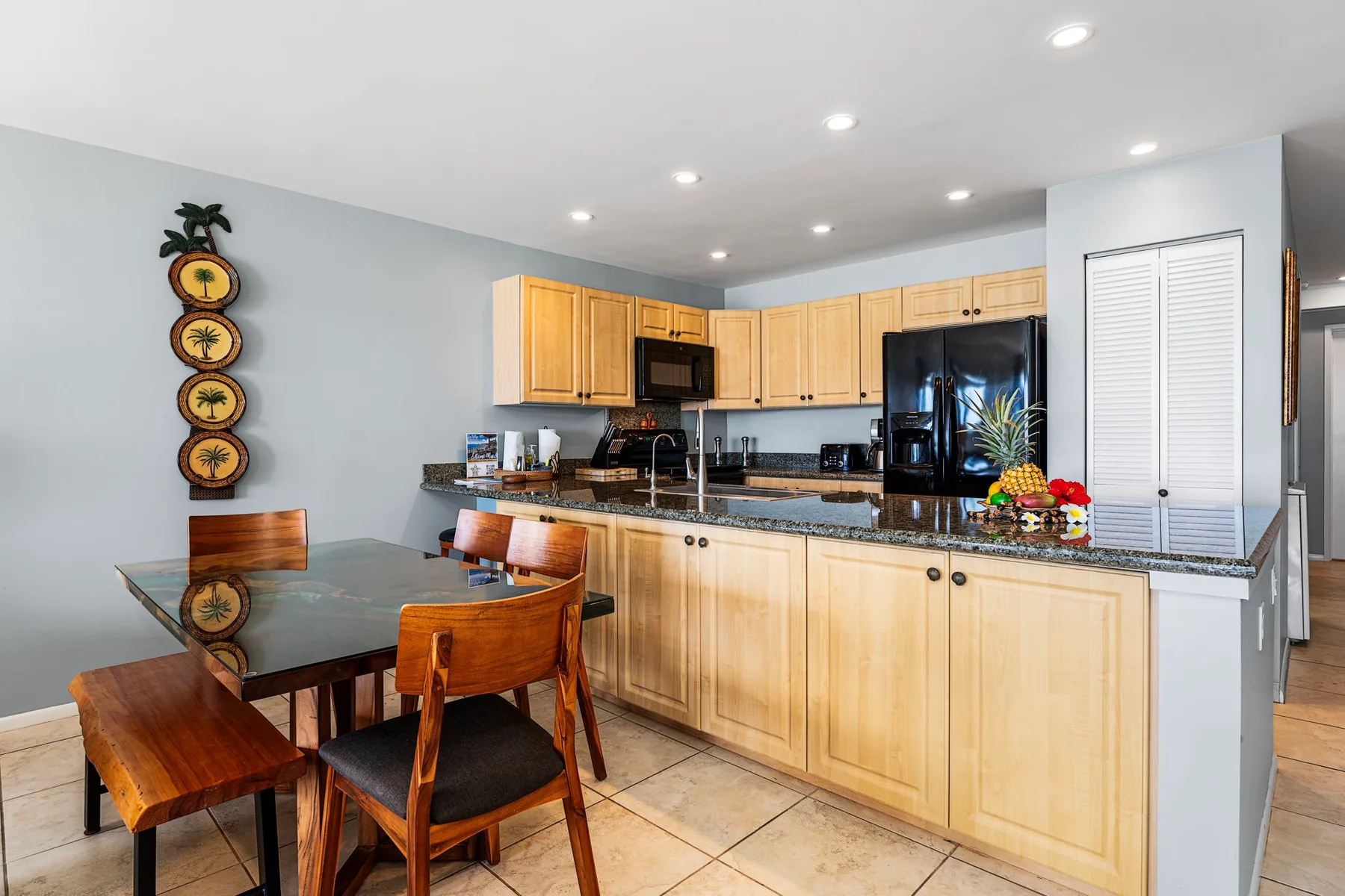 Una cocina con gabinetes de madera clara y una mesa de comedor.