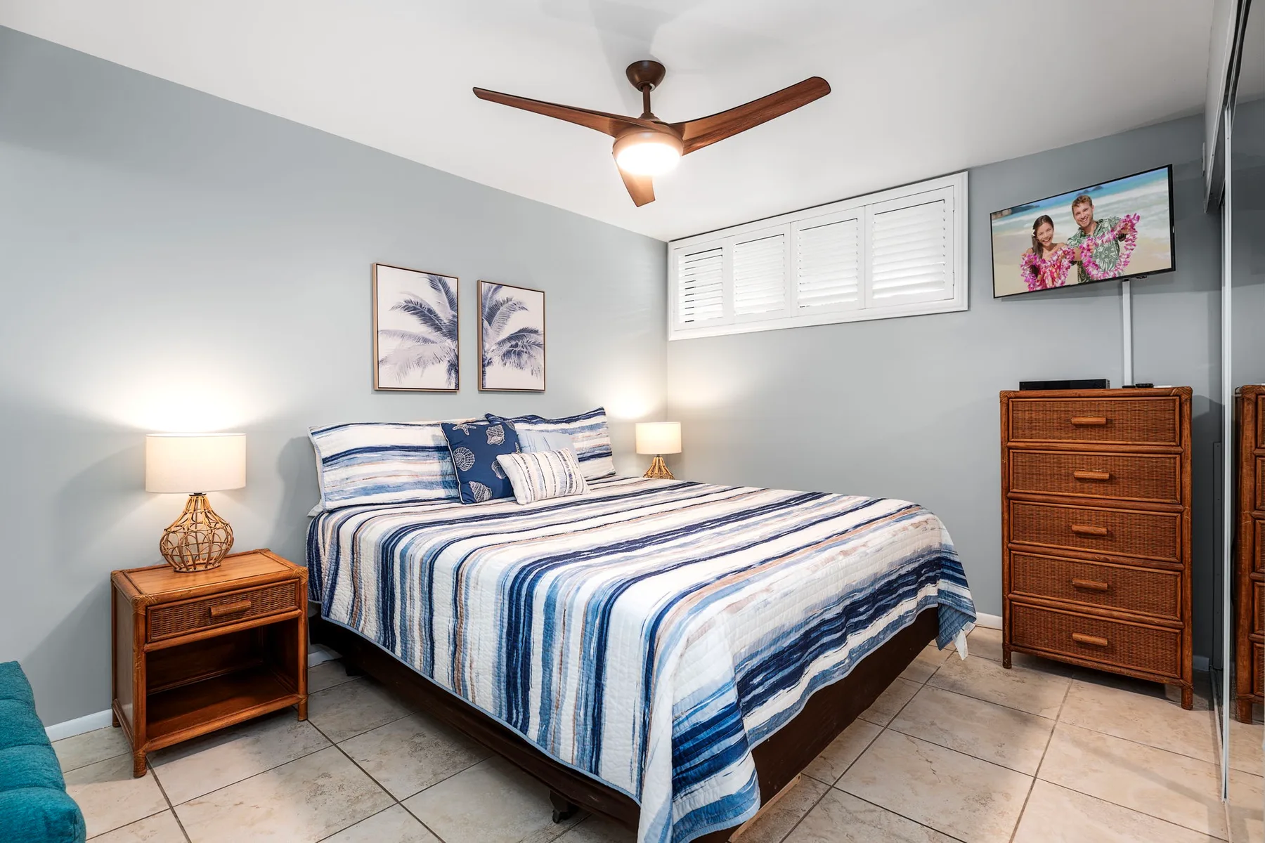 Un dormitorio con una cama vestida con ropa de cama a rayas azules y blancas.